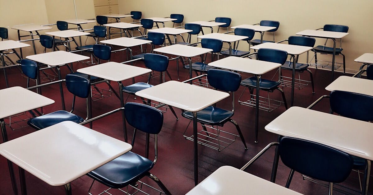 An indoor view of a modern, clean classroom with rows of empty desks and chairs.