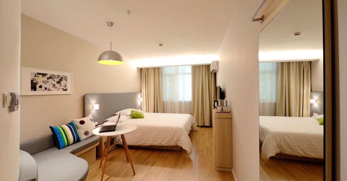 Spacious modern hotel room featuring cozy decor and neutral tones with natural light.