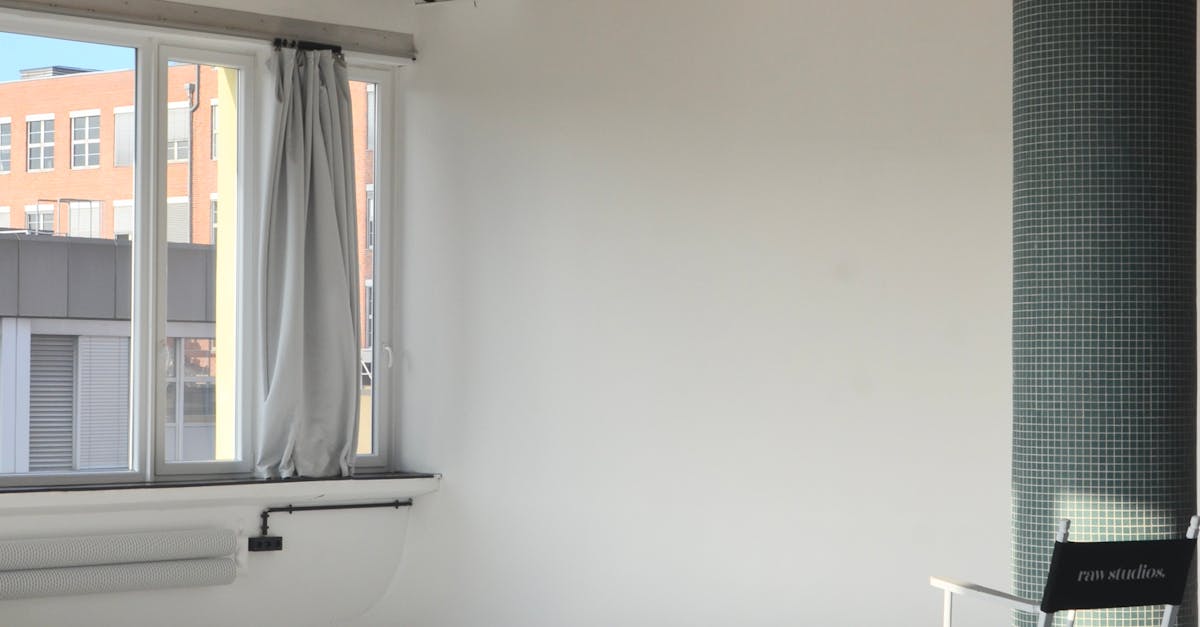 Spacious modern loft with natural light and minimalist design featuring a white chair and pillar.